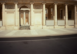a building with columns and a gate in front of it
