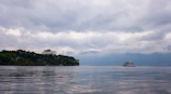 A tranquil morning scene with a cruise ship approaching a tropical island surrounded by clear blue waters.