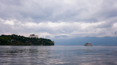 A tranquil morning scene with a cruise ship approaching a tropical island surrounded by clear blue waters.