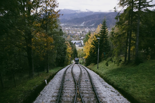 A scenic railway track winding through a forest with vibrant fall colors.