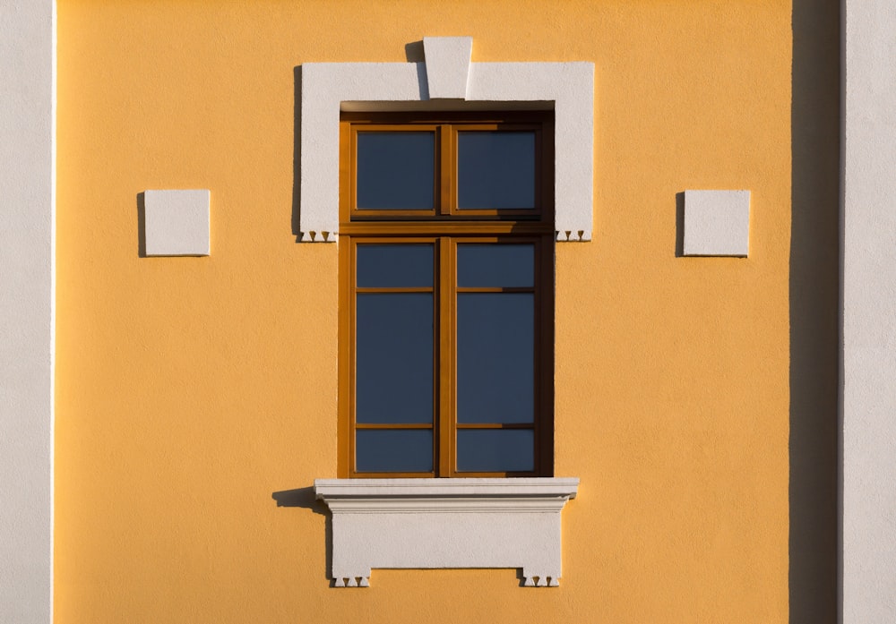 a yellow building with a window and a clock