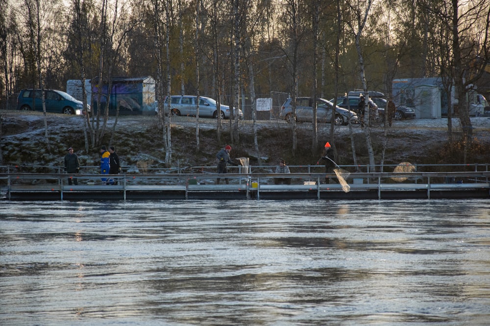 a group of people walking across a bridge over a river