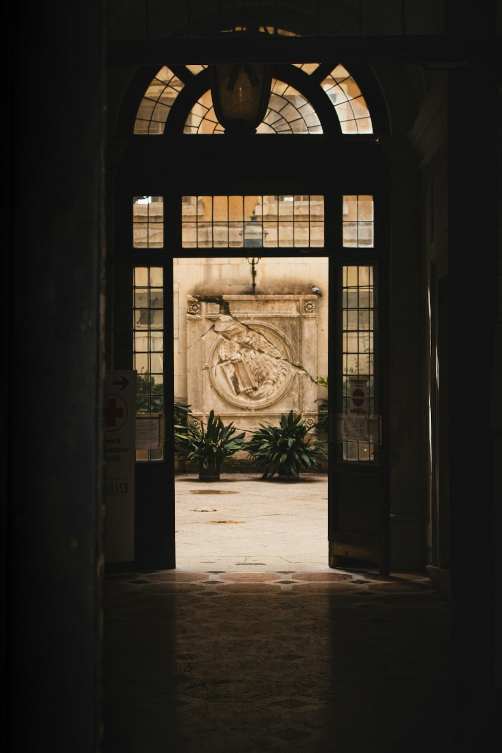 an open door leading into a building with a statue on the wall