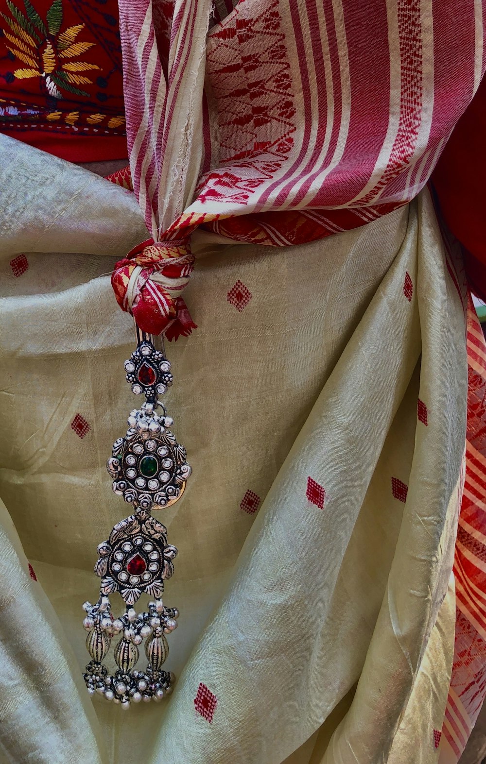 a red and white scarf with a tassel hanging from it