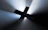 A dark background with a prominent illuminated cross shape at the center. Light rays appear to emanate from the cross, creating a dramatic and focused highlight effect.