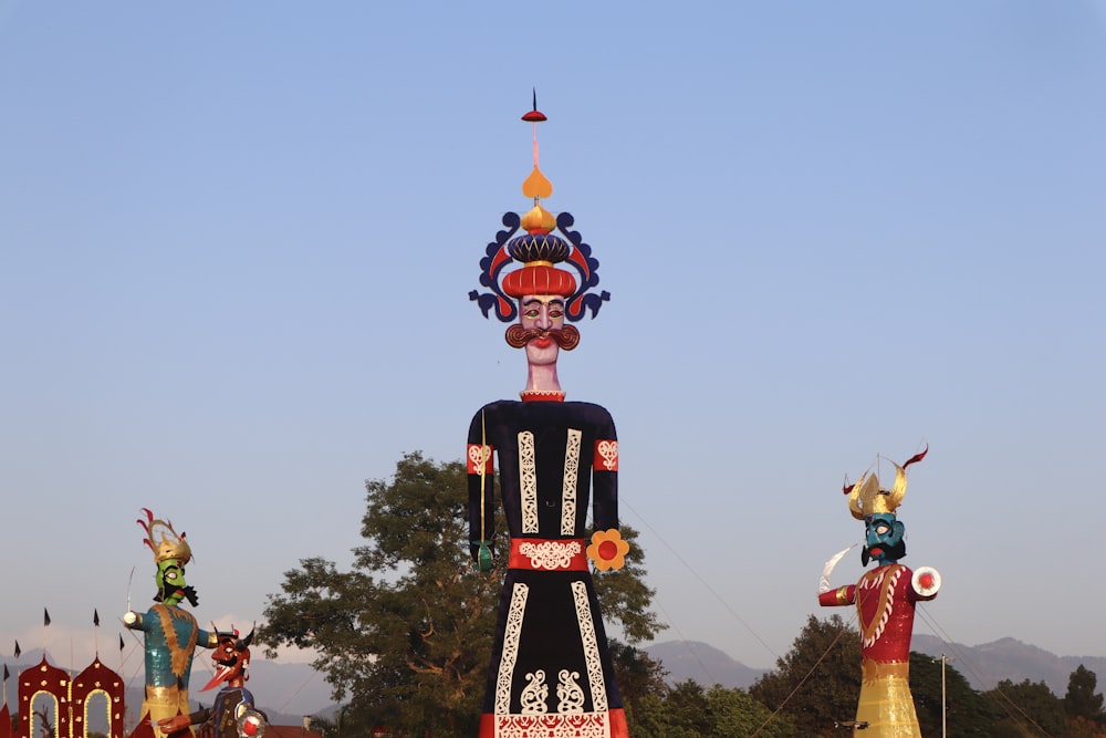a group of colorfully painted statues in front of a blue sky
