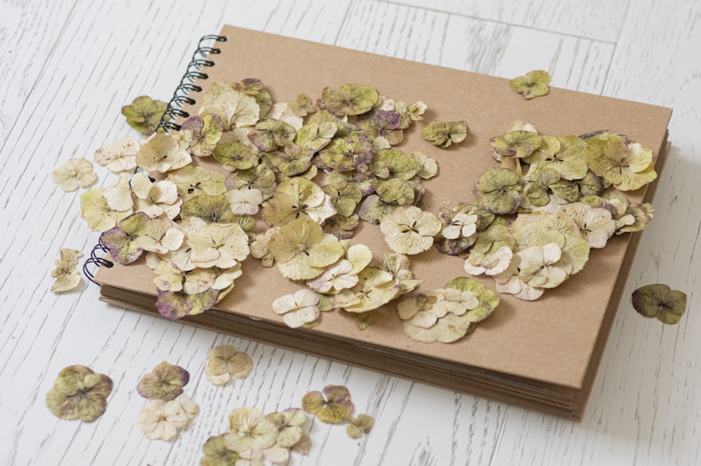 a notebook with a bunch of dried flowers on top of it