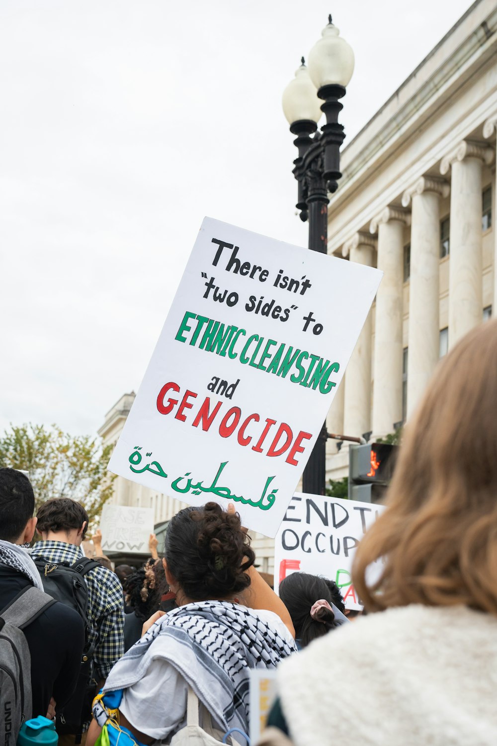 a group of people holding up signs in front of a building