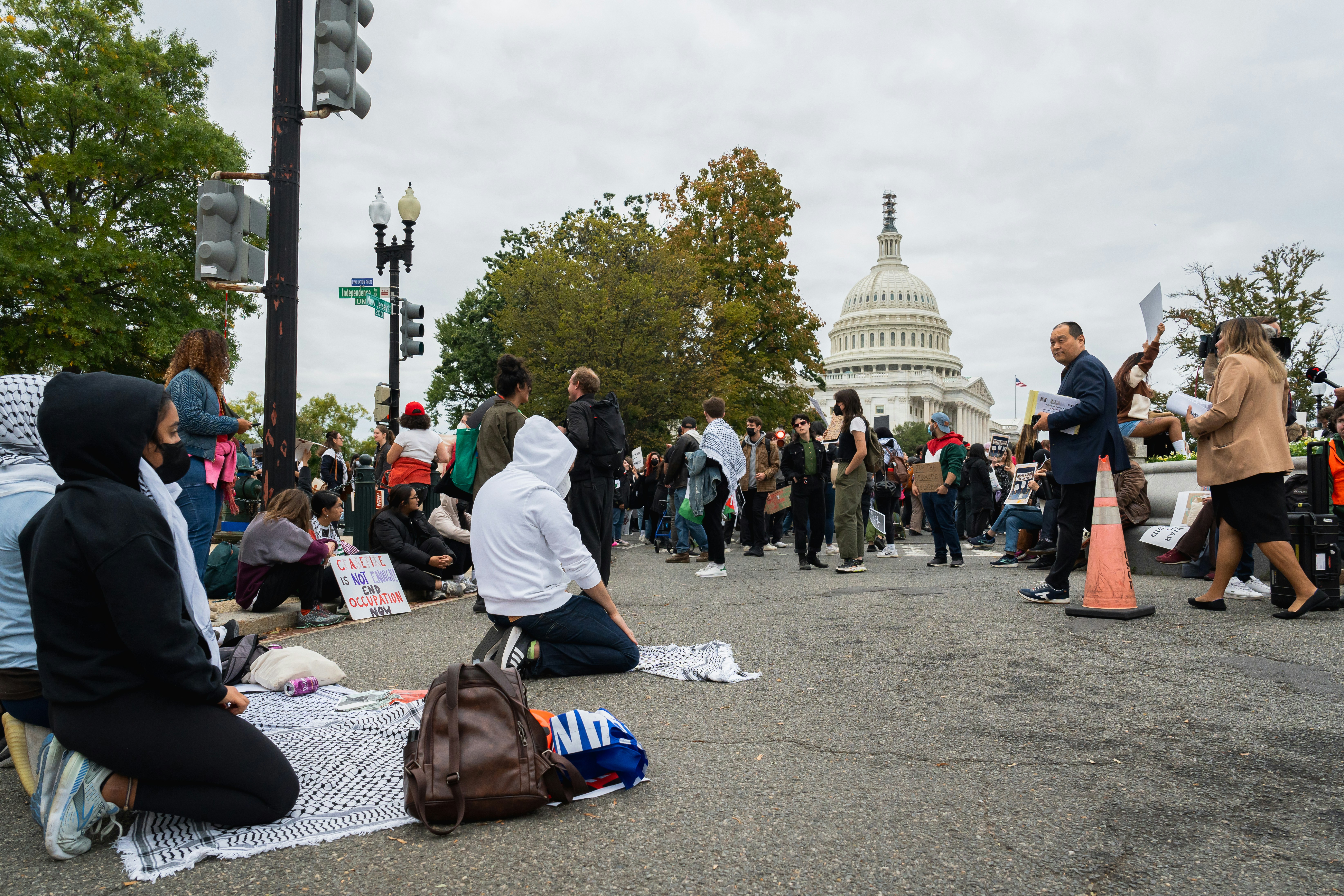 a group of people sitting on the ground in front of the capitol building, Praying outside Congress in DC