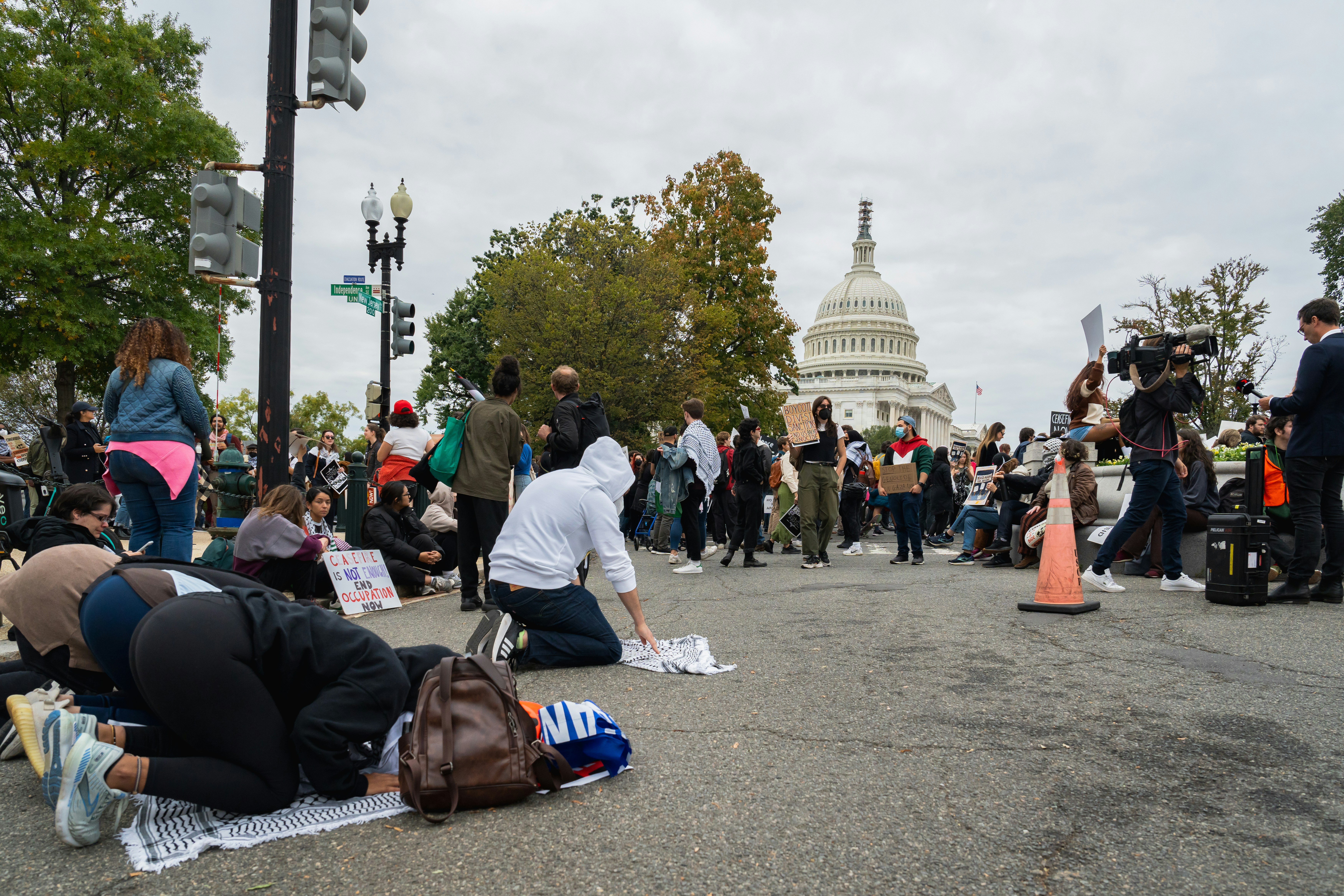 a group of people sitting on the ground in front of the capitol building