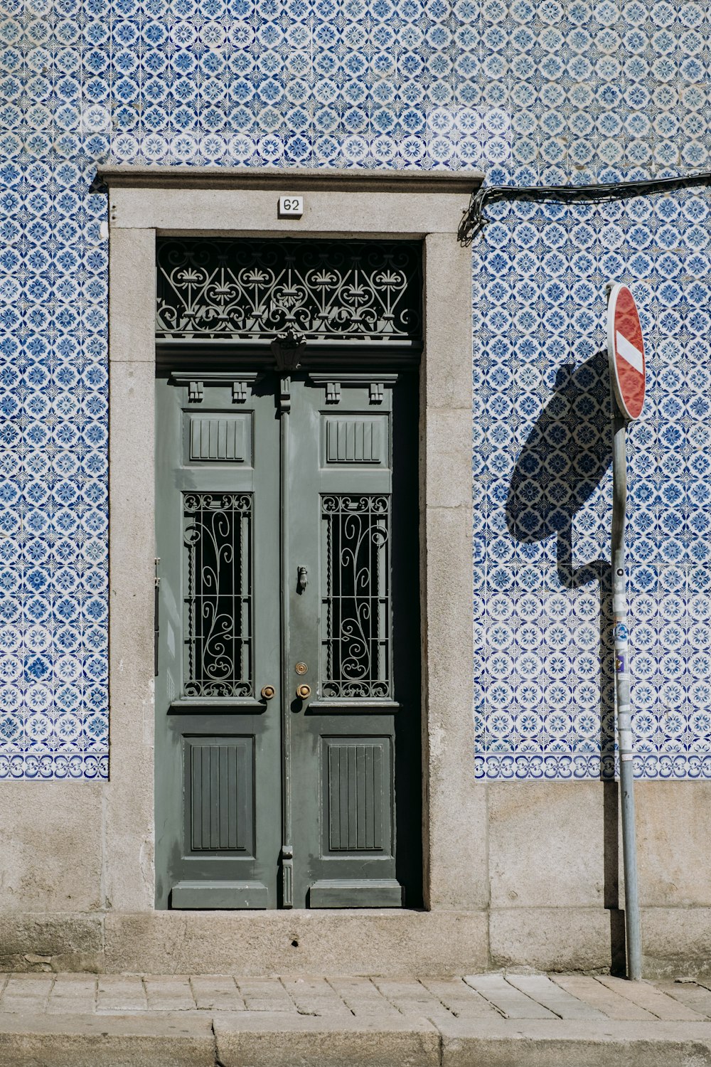 a blue and white building with two doors and a street sign