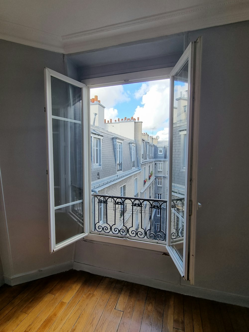 an empty room with a window and a balcony