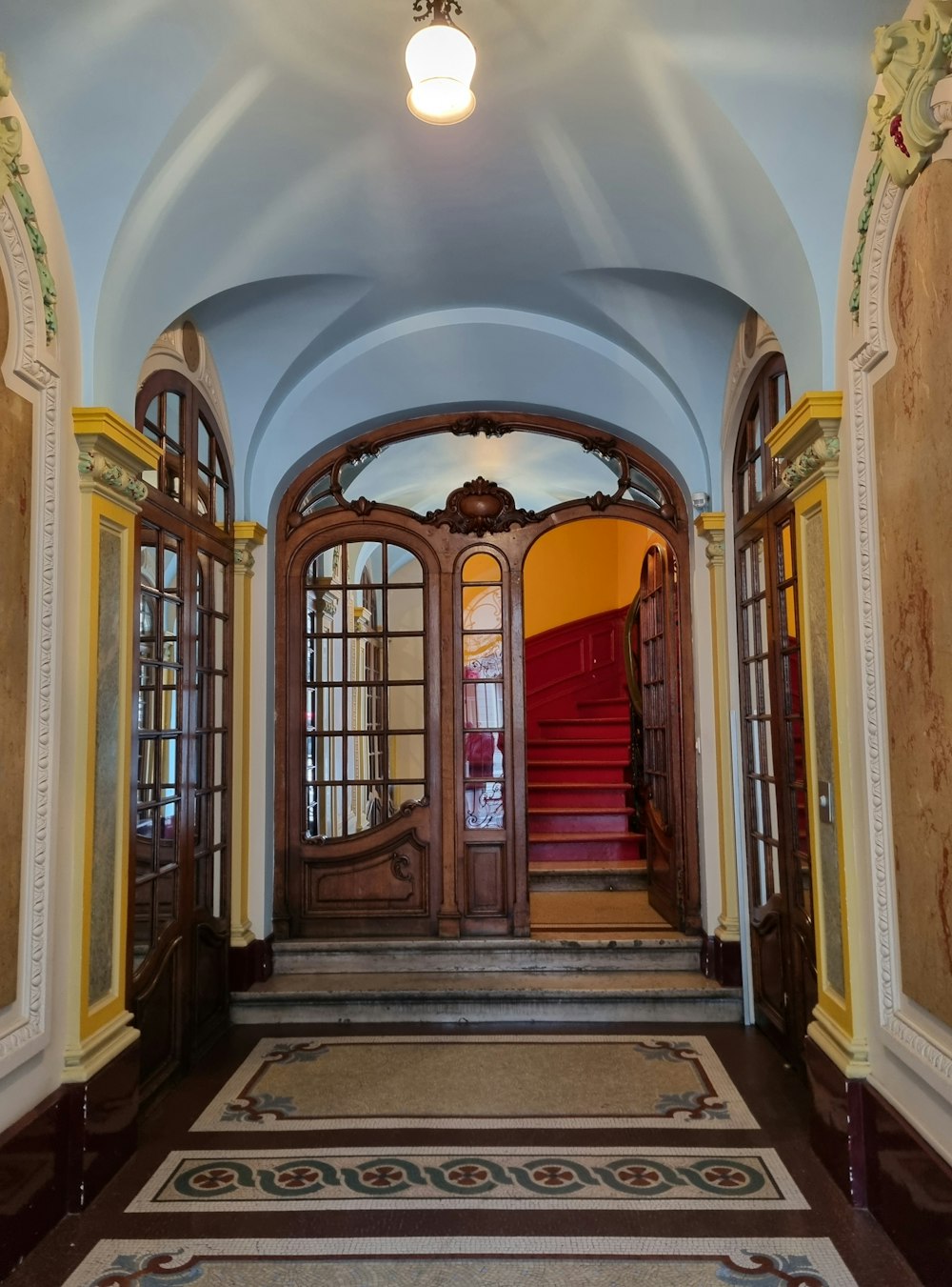 a doorway with a red carpet and a red stair case