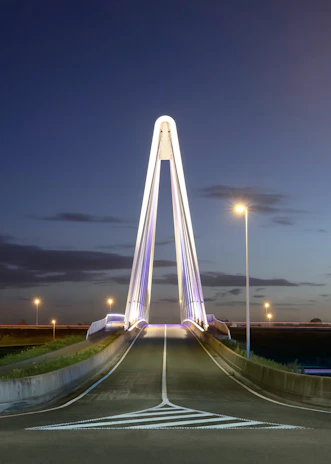 A completed modern bridge illuminated at dusk, showcasing quality construction.