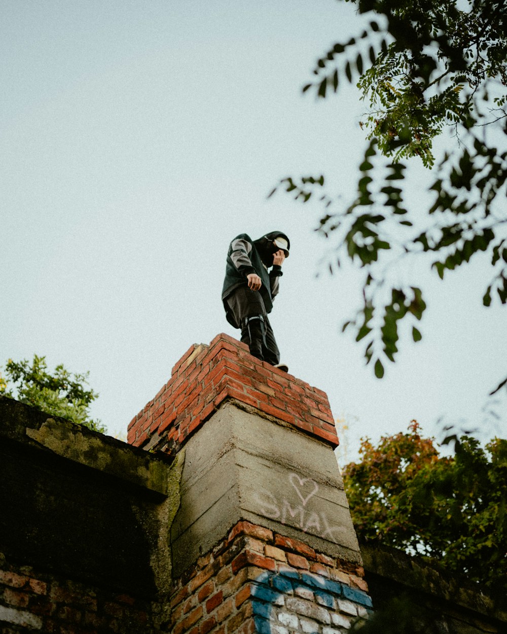 a man standing on top of a brick wall