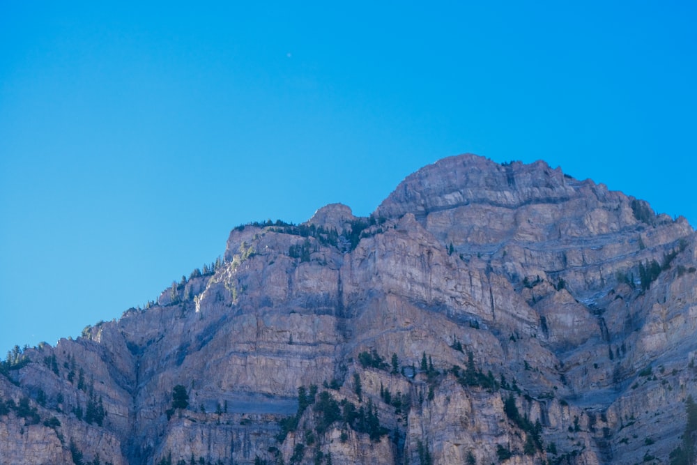 a very tall mountain with a full moon in the sky