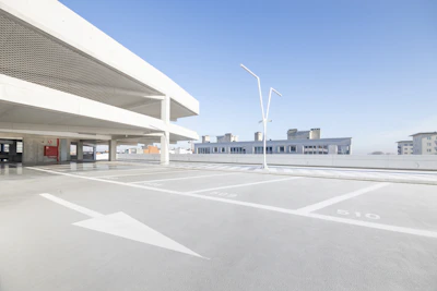 Wide shot of a freshly striped commercial parking lot with crisp white and yellow markings under clear daylight.