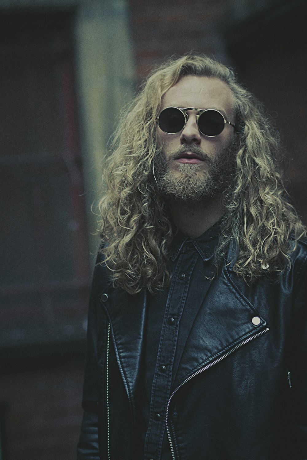 a man with long hair wearing a leather jacket