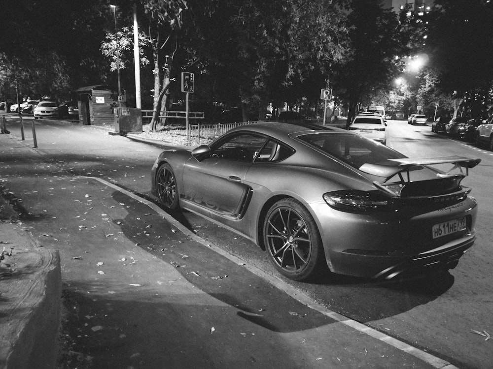 Una foto en blanco y negro de un coche aparcado al lado de la carretera