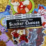 A collection of colorful and whimsical stickers displayed on a glittery gold background. The central black sticker with glittery text reads 'I'm Judging Your Sticker Choices' followed by 'Kawaii-est Little Stationery Store.' Surrounding this sticker are various images, including a fox with a red and white mushroom, a bottle with ribbons, a crescent moon with stars, a purple cat, a bird amidst roses, and a monochrome skeletal figure with a bouquet of roses. Some promotional text and numbers appear on a white background towards the top.