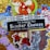 A collection of colorful and whimsical stickers displayed on a glittery gold background. The central black sticker with glittery text reads 'I'm Judging Your Sticker Choices' followed by 'Kawaii-est Little Stationery Store.' Surrounding this sticker are various images, including a fox with a red and white mushroom, a bottle with ribbons, a crescent moon with stars, a purple cat, a bird amidst roses, and a monochrome skeletal figure with a bouquet of roses. Some promotional text and numbers appear on a white background towards the top.