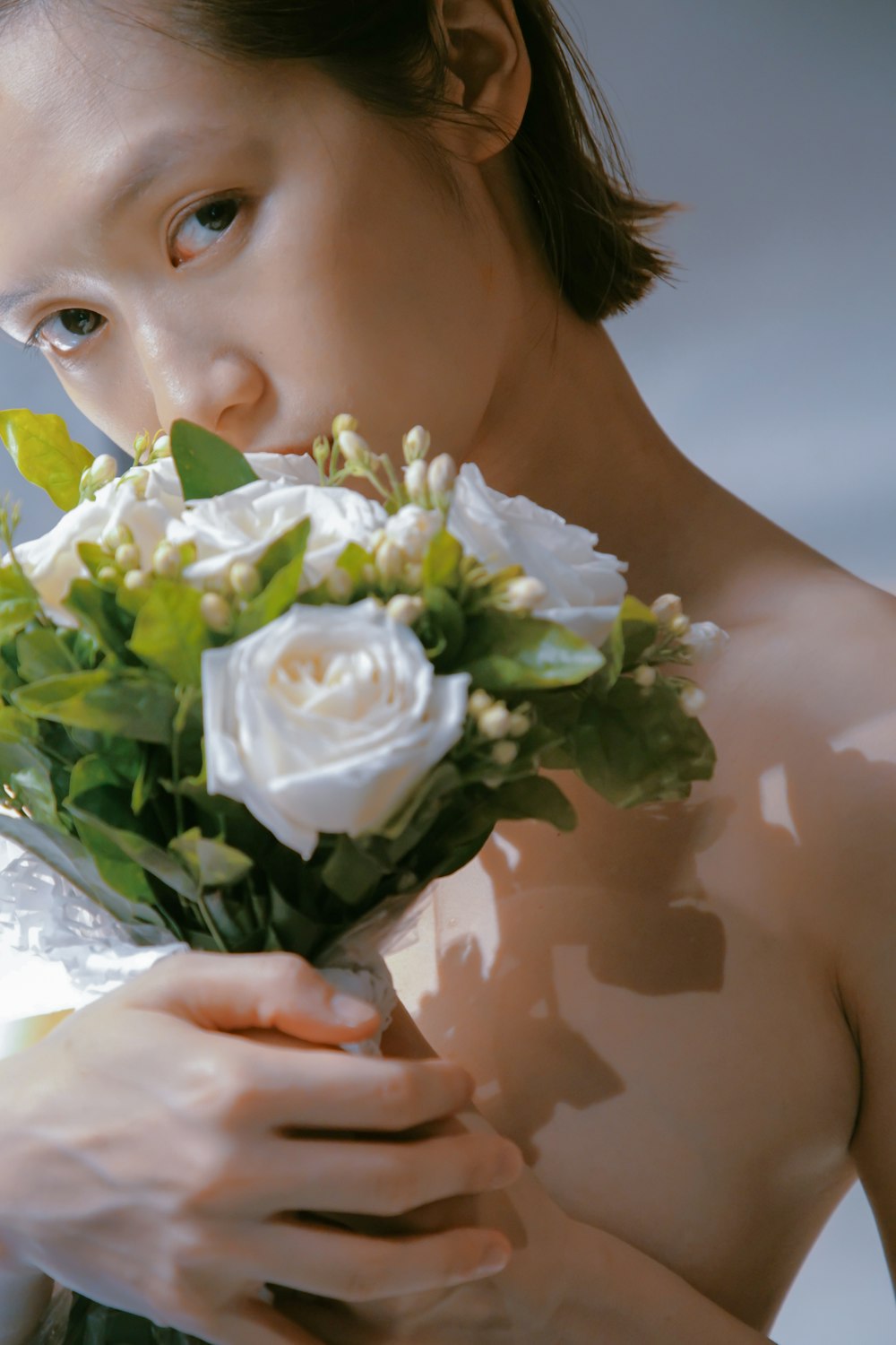 a woman holding a bouquet of white flowers