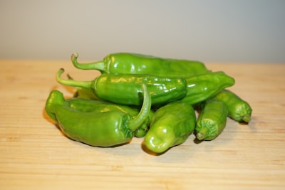 Close-up of vibrant green chili peppers arranged on a kitchen counter.