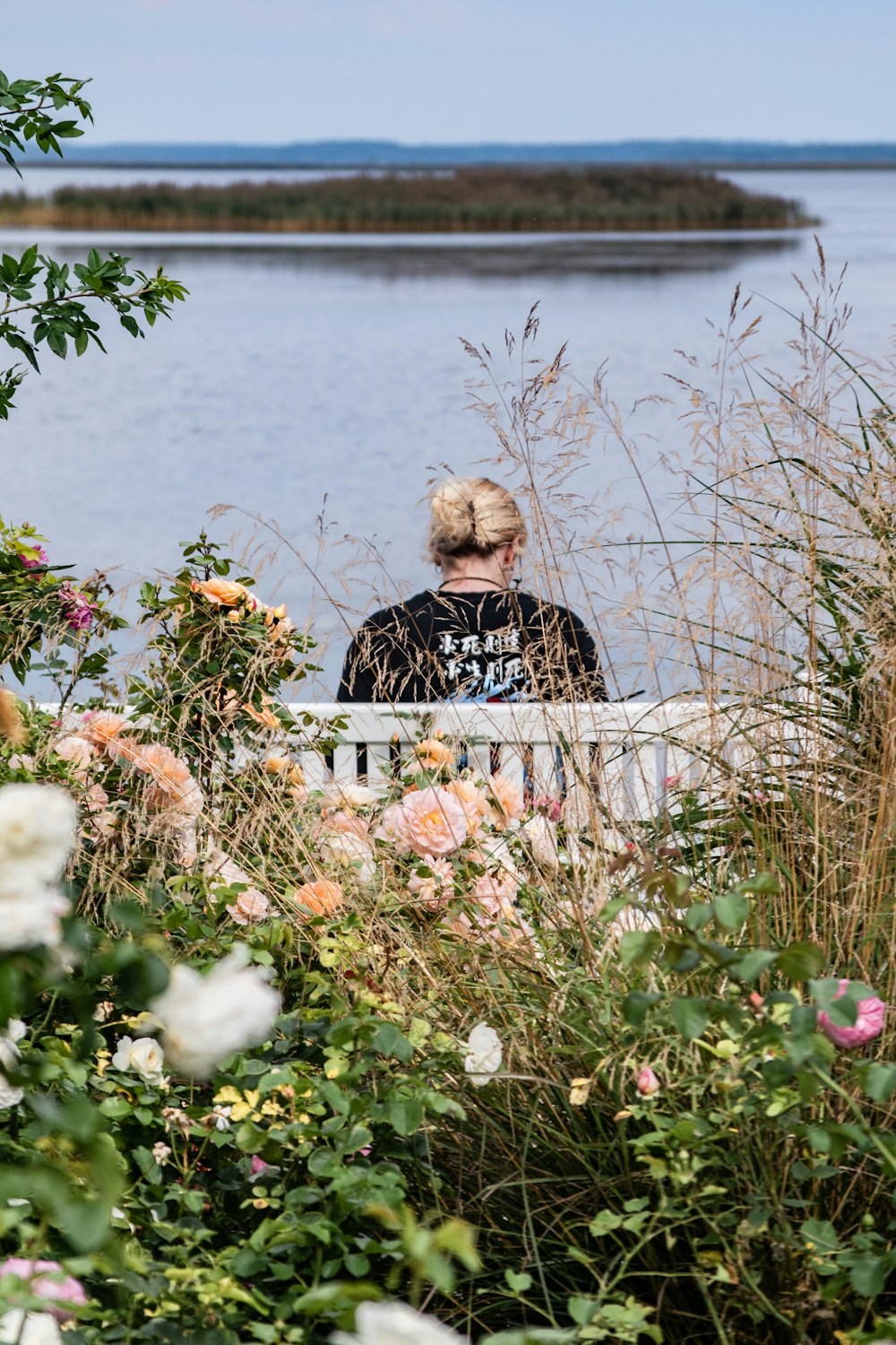 two people sitting on a bench near a body of water