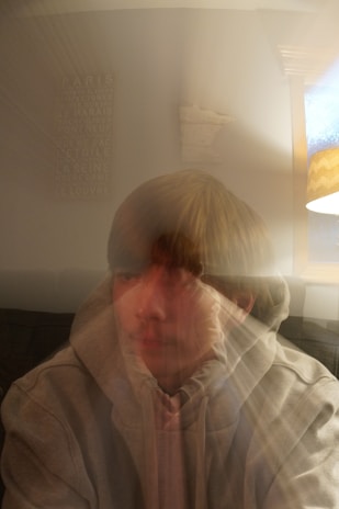 A cozy scene of a person wearing a hoodie with a subtle French regional emblem, surrounded by traditional French decor.