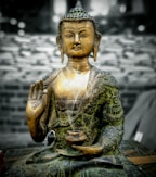 A close-up of a beautifully crafted Buddha statue surrounded by incense sticks.