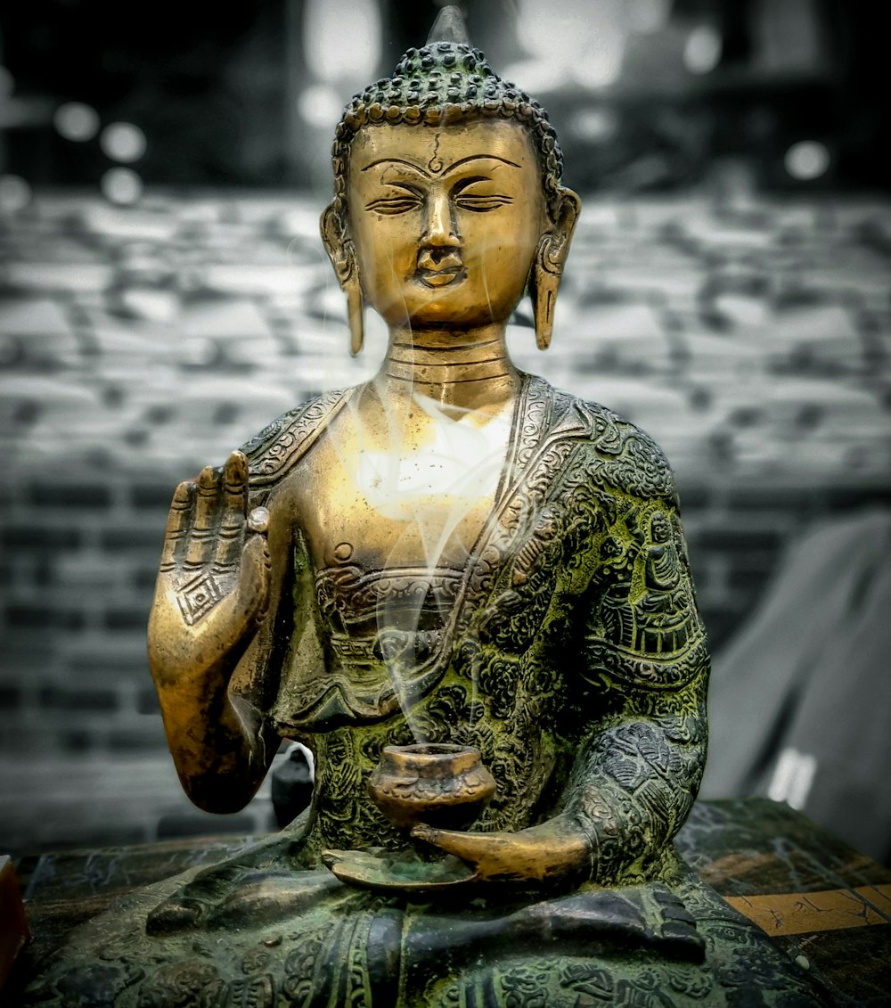 a buddha statue sitting on top of a wooden table