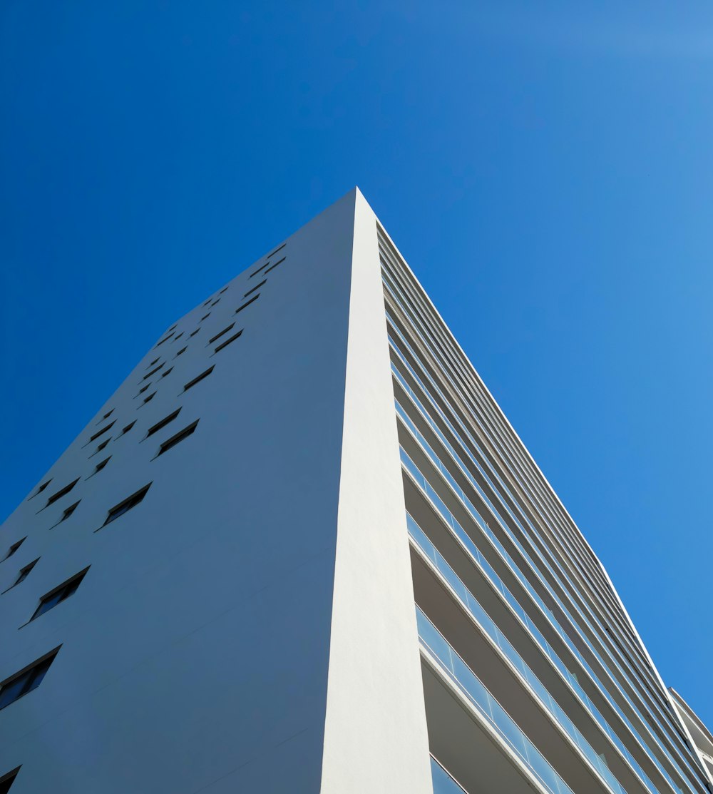 a tall white building with a blue sky in the background