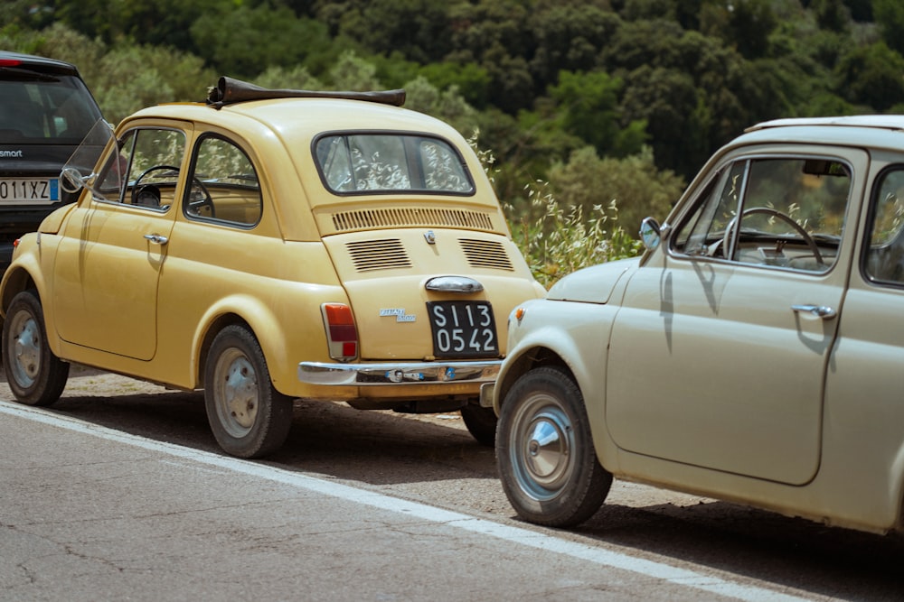 a yellow car and a black car on a road