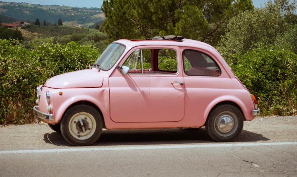 a pink car parked on the side of the road