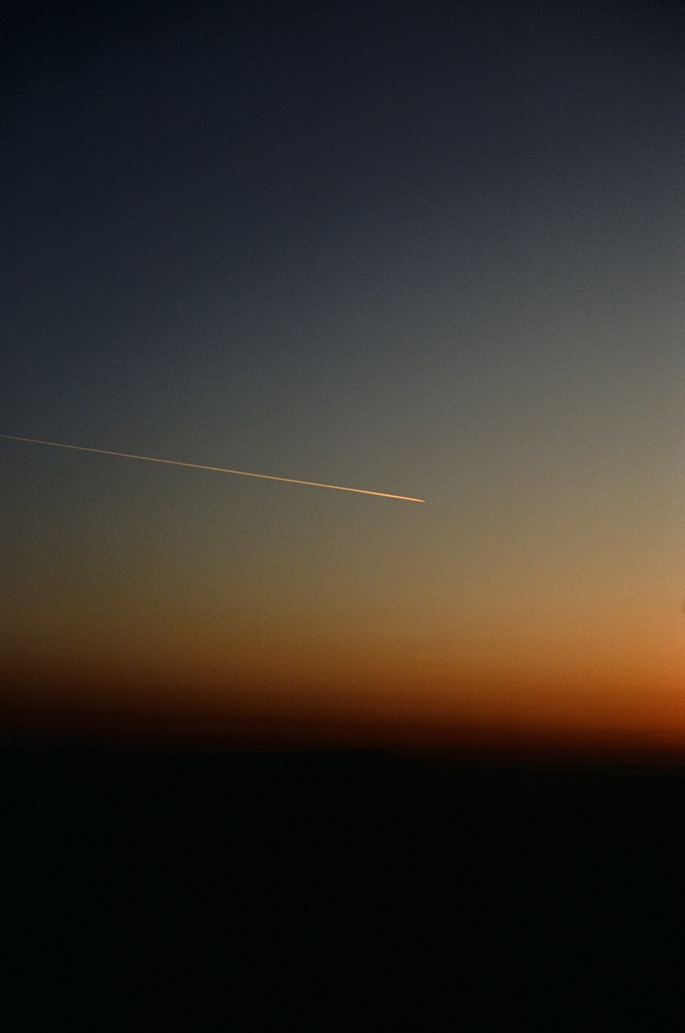 Un aereo che vola nel cielo al tramonto