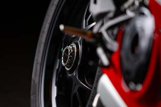 Close-up of a motorcycle wheel rim freshly painted in glossy black with red accents.