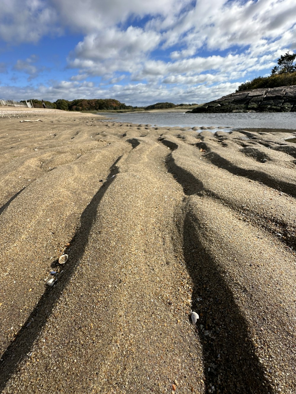 a sandy beach with a body of water in the background