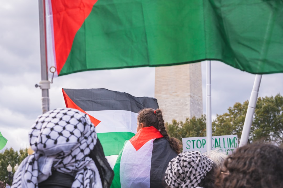 a group of people holding flags in front of a building, Free Palestine March
