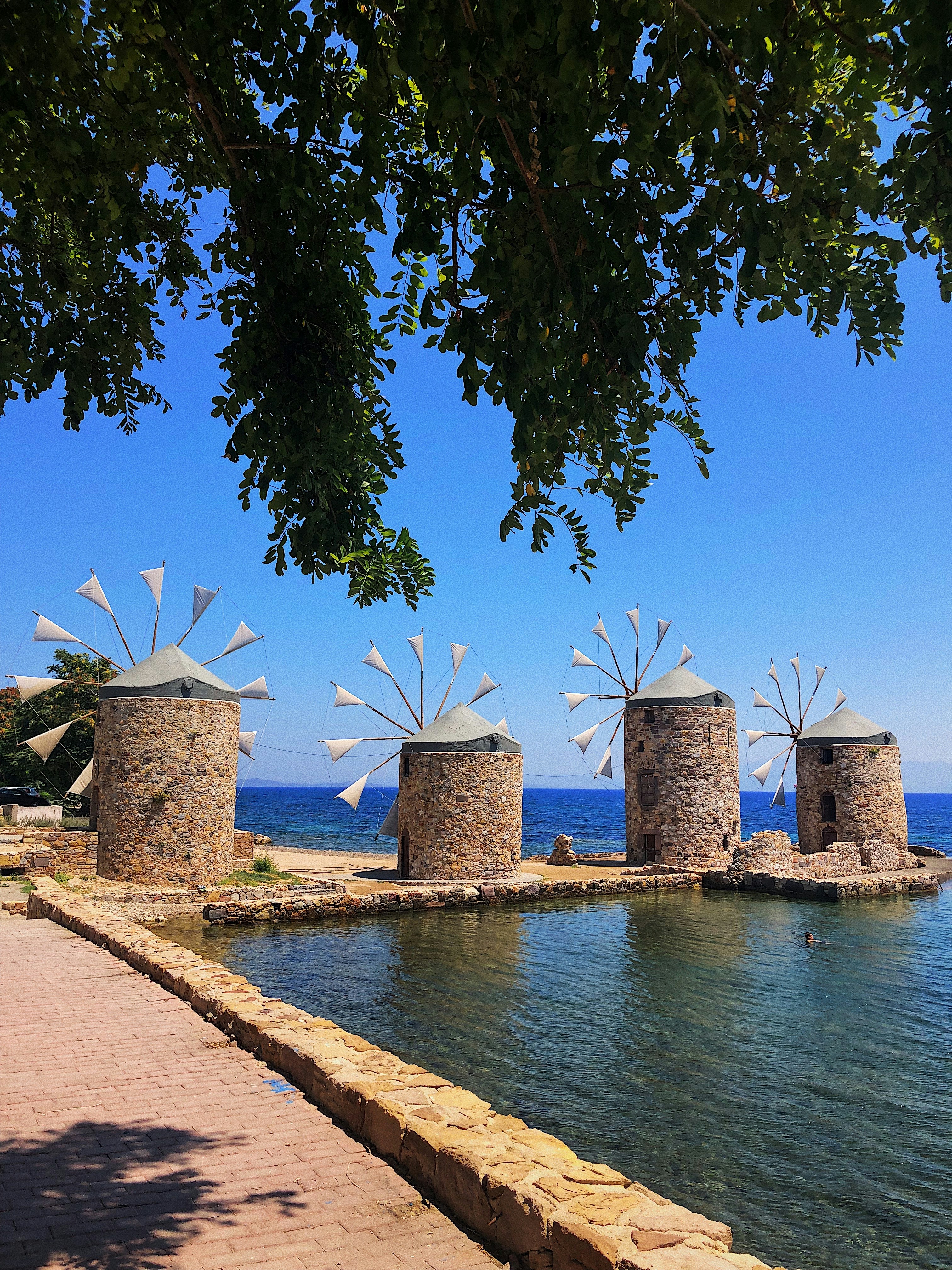 a couple of windmills sitting on top of a body of water