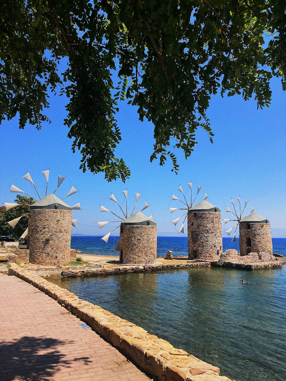 a couple of windmills sitting on top of a body of water