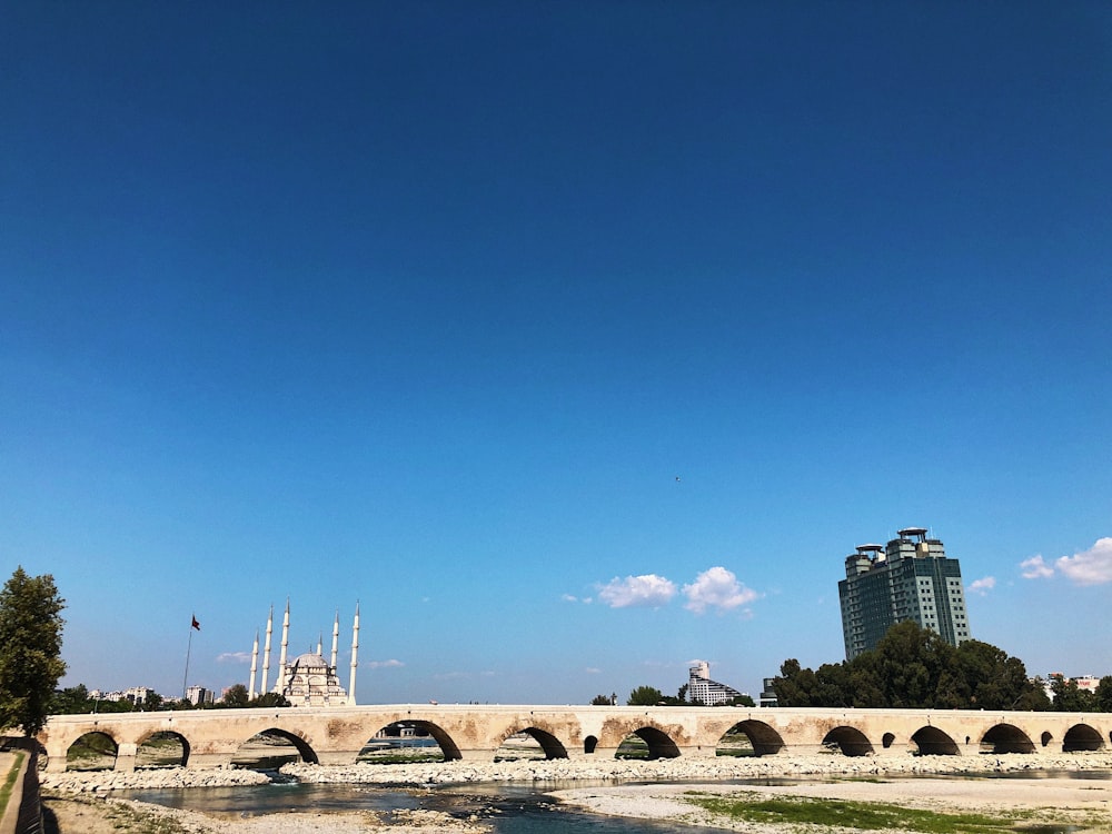 a bridge over a body of water with buildings in the background