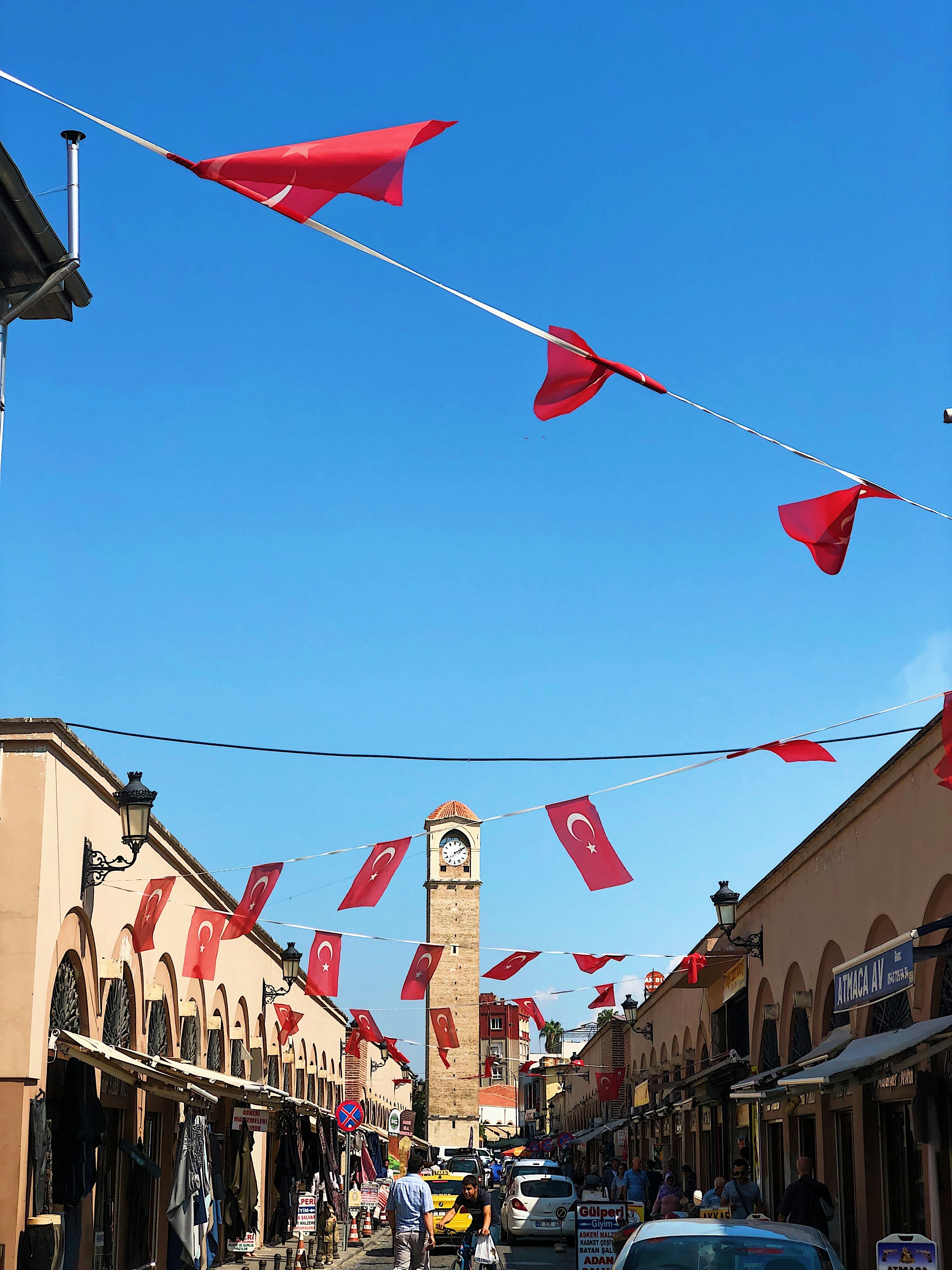 una calle de la ciudad con una torre del reloj al fondo