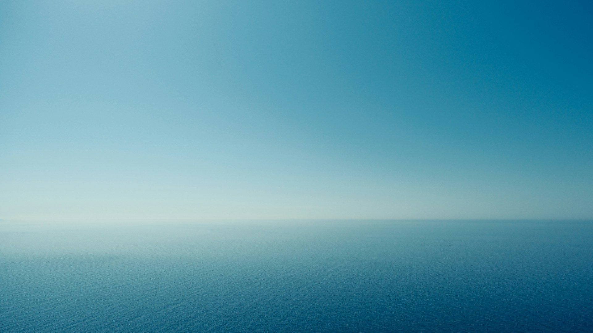 a large body of water under a bright blue sky