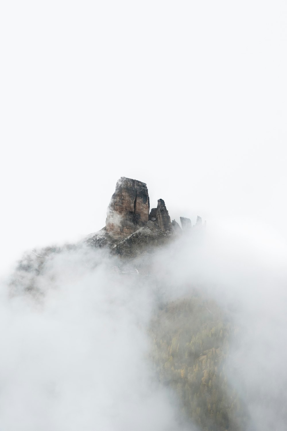 a mountain covered in fog and clouds on a cloudy day