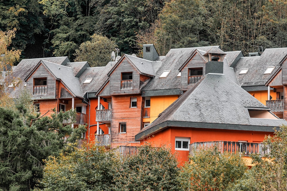 a row of orange houses with trees in the background