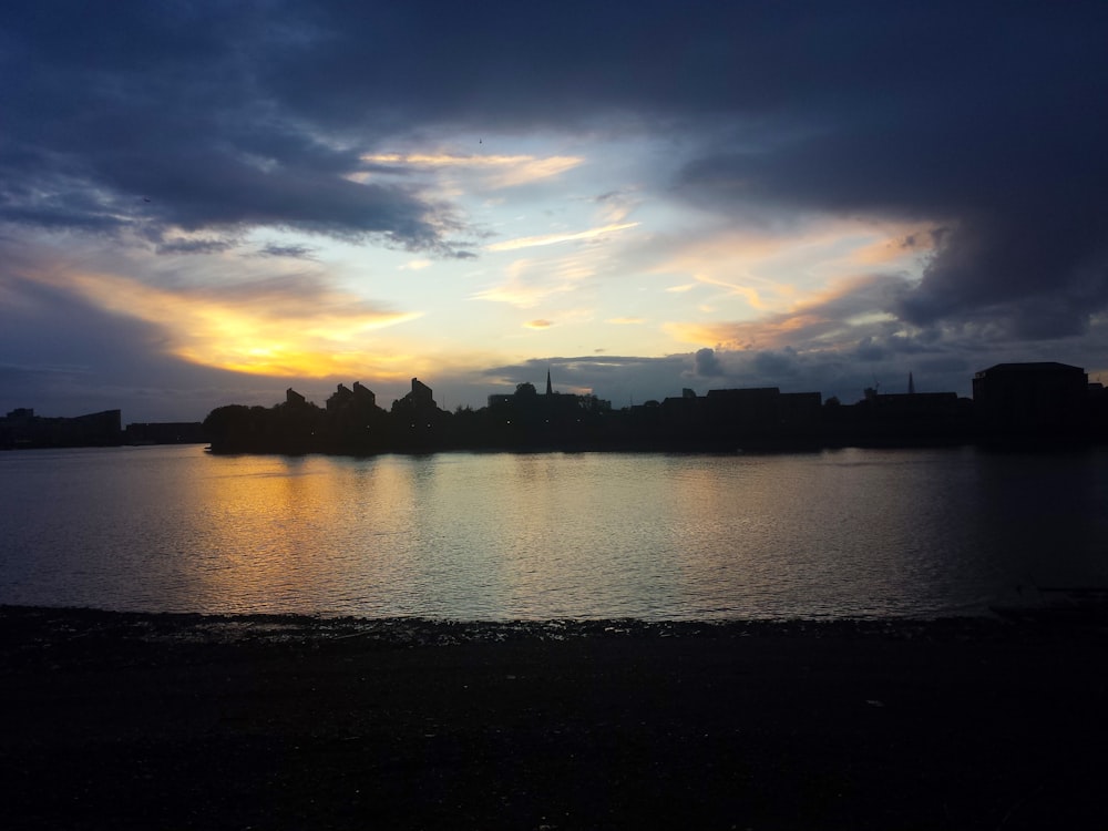 a body of water with a sunset in the background