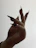 Close-up of a European woman's hand with a flawless deep red manicure against a black background.