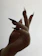 Close-up of a European woman's hand with a flawless deep red manicure against a black background.