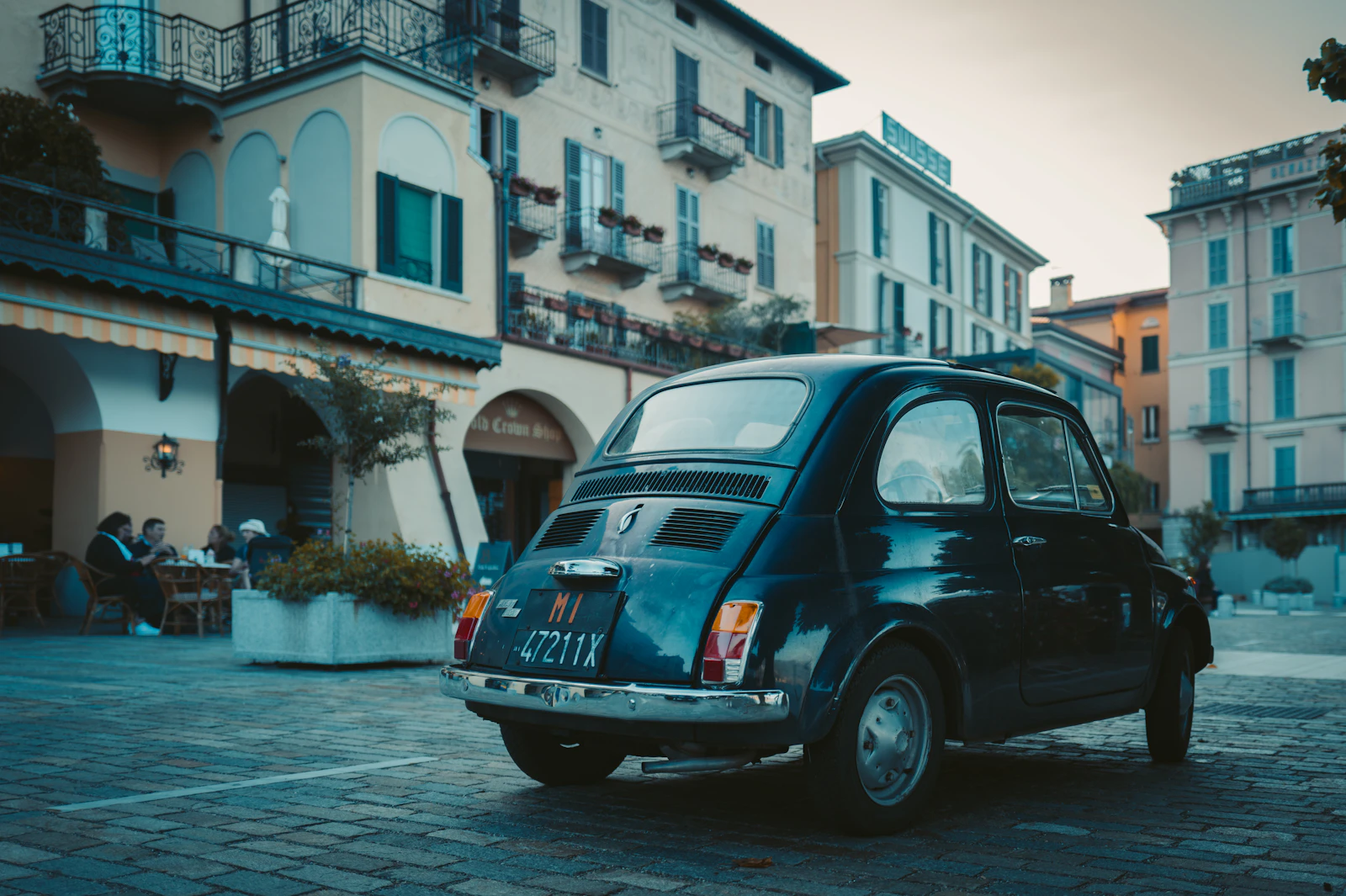 Small vintage car parked on a cobblestone square in Bellagio on Lake Como, Italy