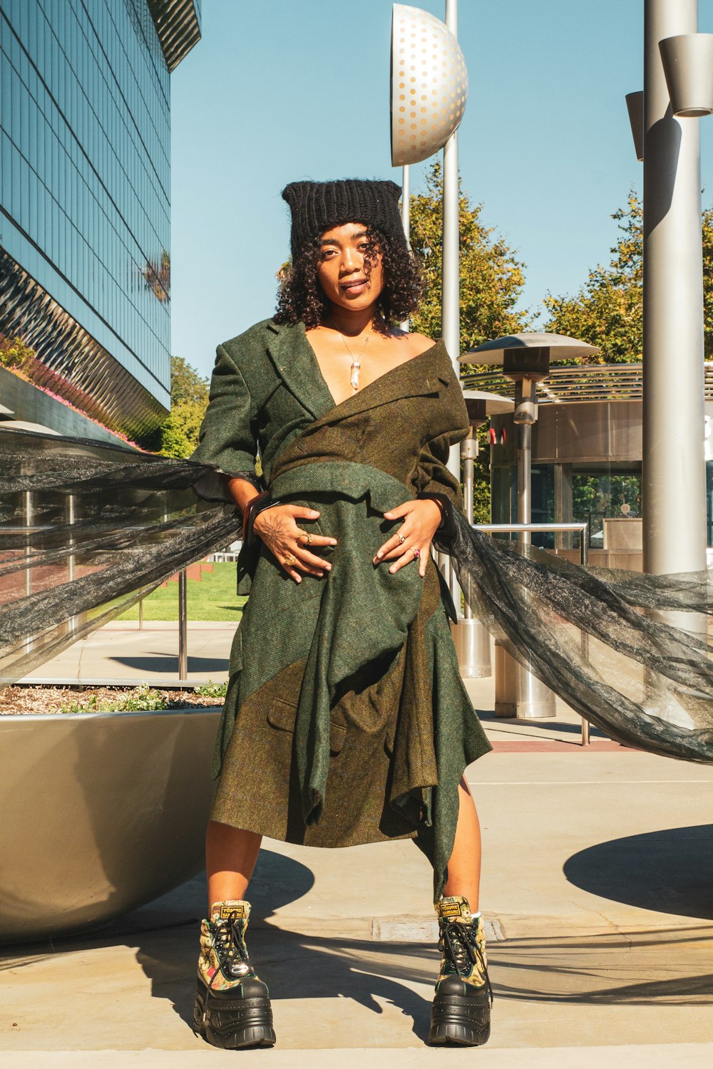 a woman in a dress and hat posing for a picture